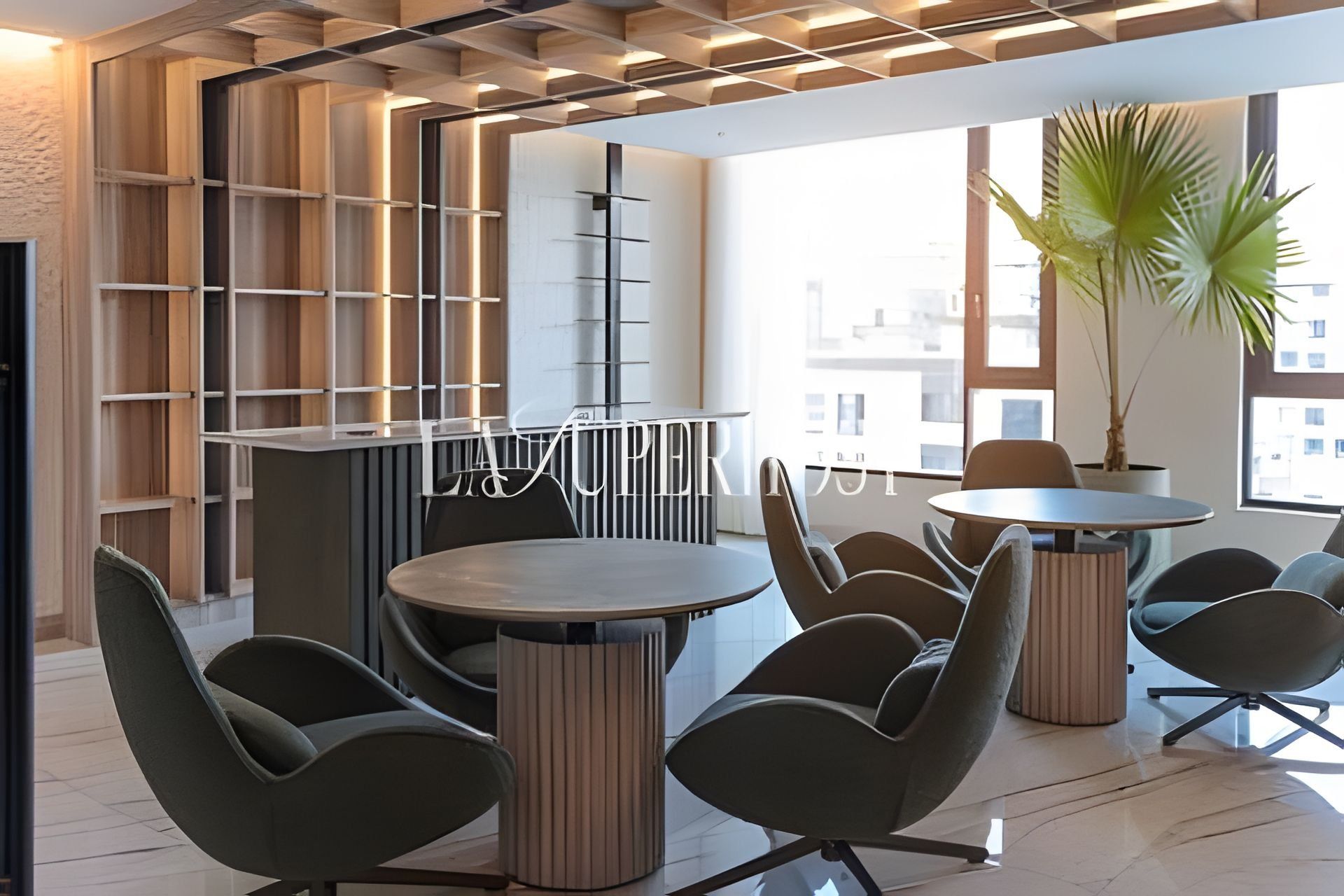 A modern interior with a round table and chairs, a bookshelf, and a potted plant.