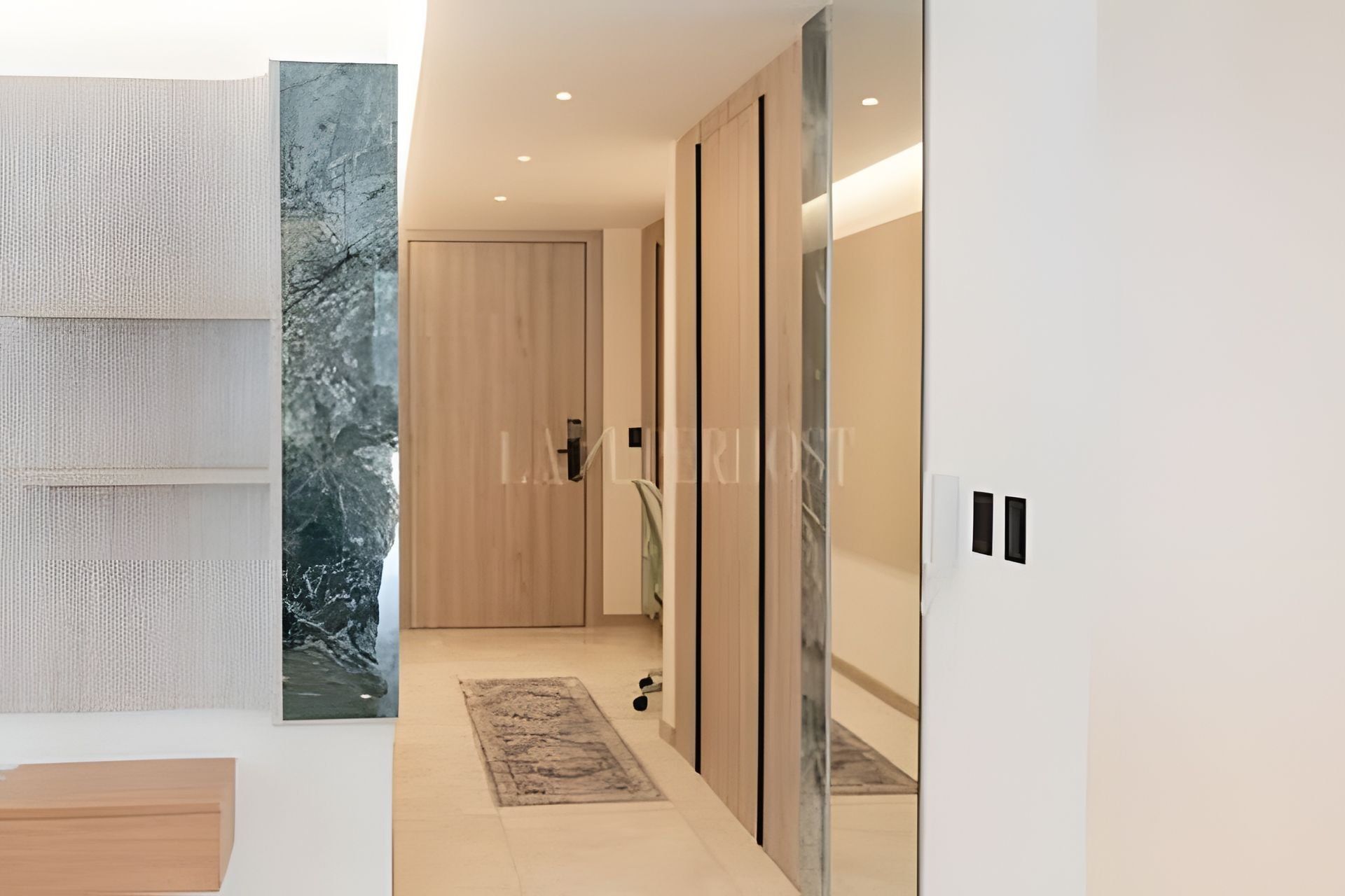 A modern interior with a wooden door, a patterned wall, and a marble accent wall.