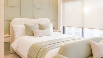 A modern bedroom with a large bed, a nightstand, and a window with curtains.