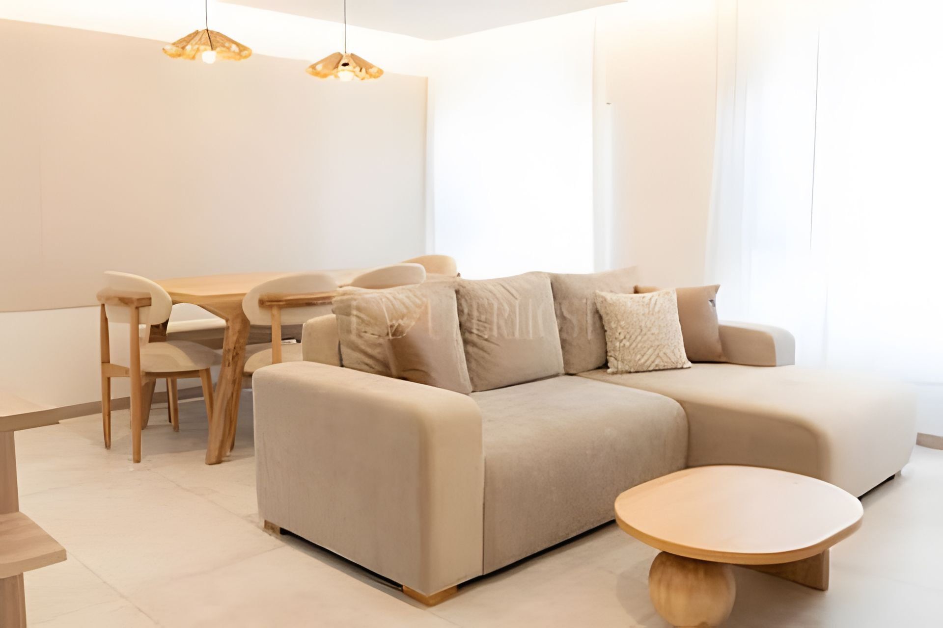Ein modernes Wohnzimmer mit einer Couch, einem Couchtisch und einem Essbereich mit Stühlen und einem Tisch.