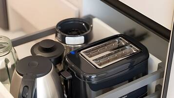 Un cassetto della cucina con un tostapane, un vasetto e un contenitore.
