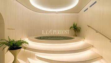 Un interior moderno con una escalera curva, una fuente central y un letrero que dice 'LA SUPERIOST'.