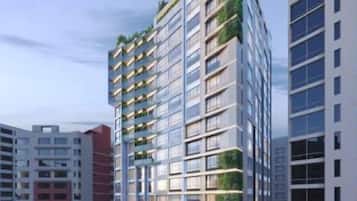 Un immeuble moderne de grande hauteur, doté de nombreux balcons et entouré d’autres bâtiments.