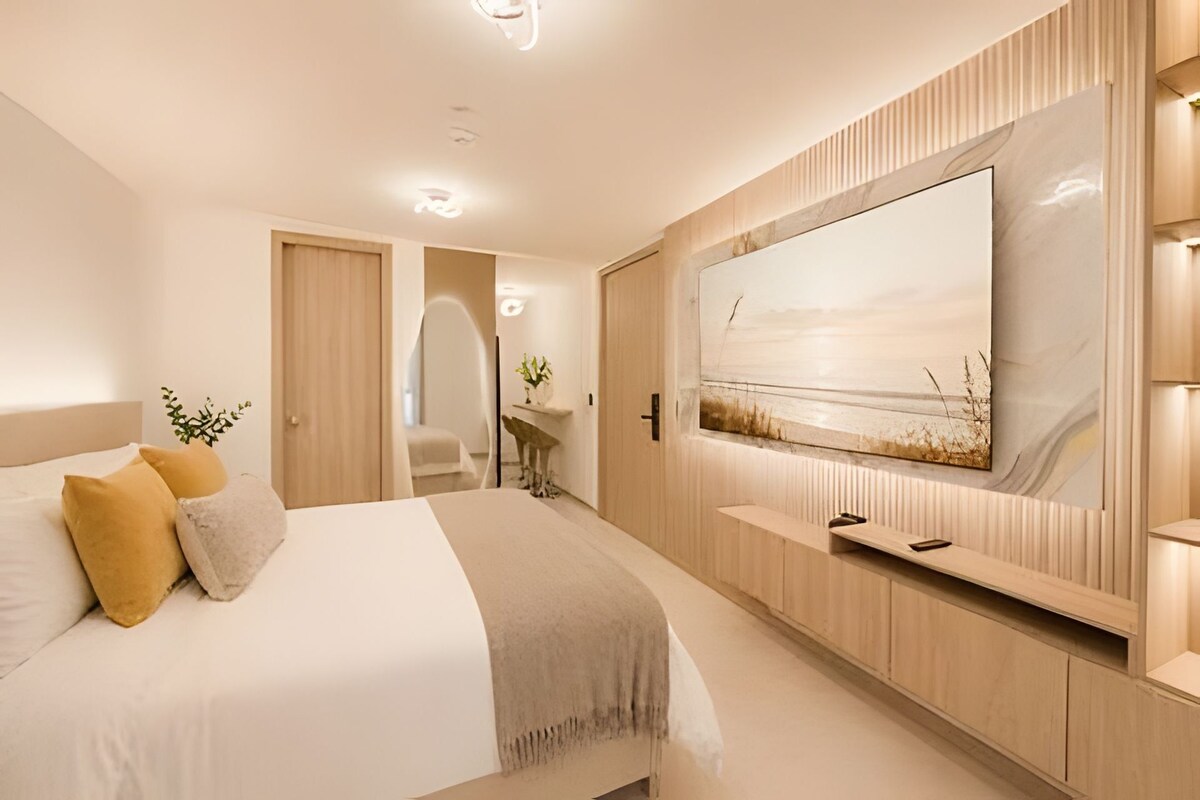 Un dormitorio moderno con una cama grande, un televisor de pantalla plana montado en la pared y un diseño minimalista.
