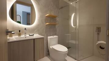 Ein modernes Badezimmer mit Toilette, Waschbecken und Dusche.