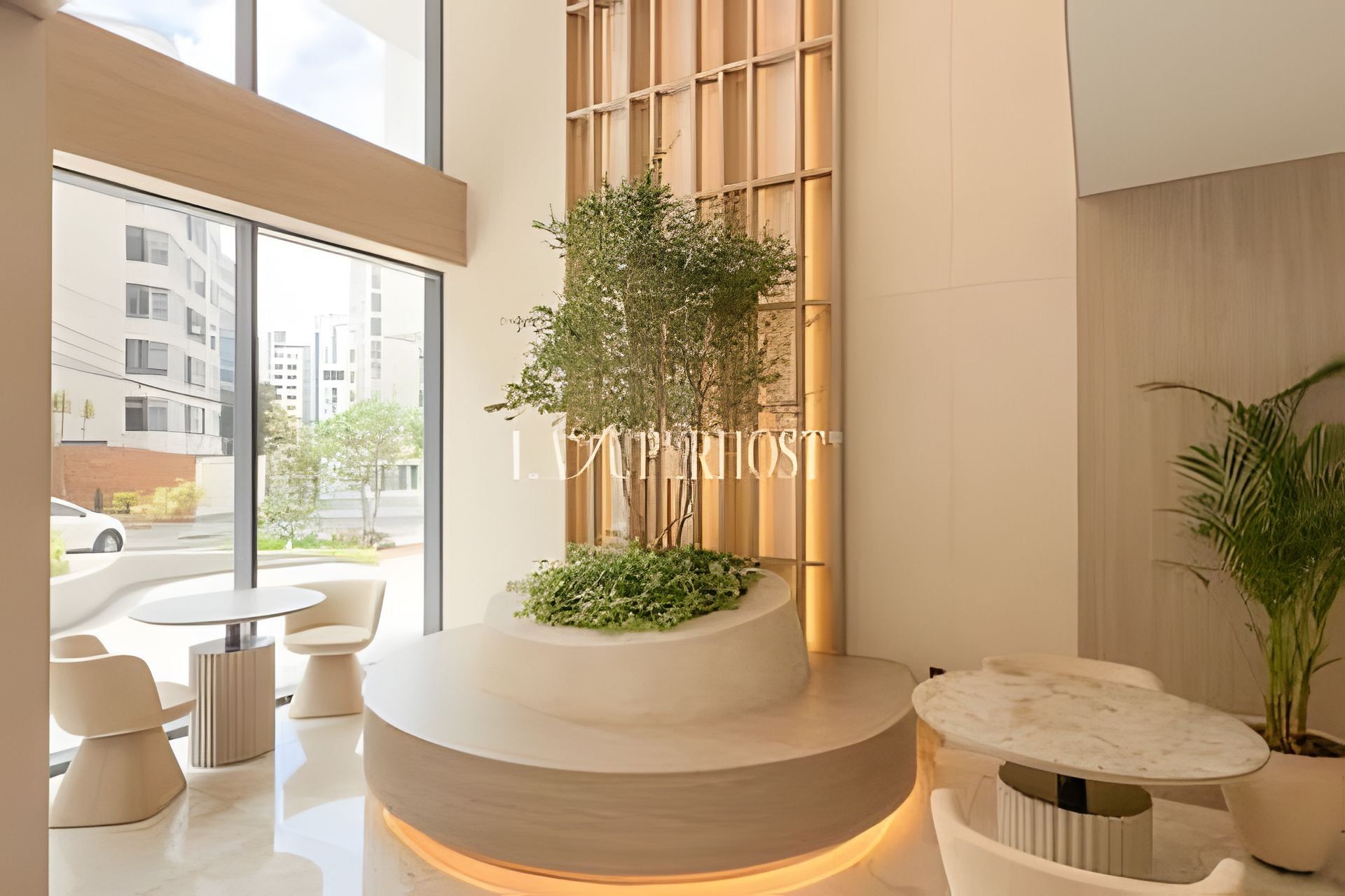 Un interior moderno con una recepción, zona de estar y un gran ventanal con vistas al exterior.