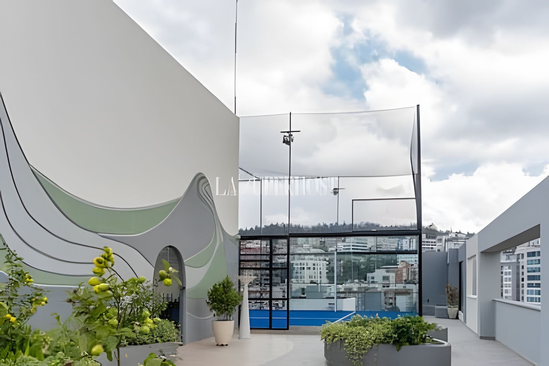 A modern building with a curved facade, large windows, and a rooftop garden with potted plants.