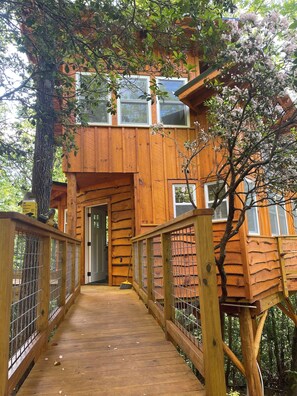 A wooden treehouse with a wooden deck and a metal railing. - Treehouse Escape w/Hot Tub, Near Smoky Mtn (Bryson City)