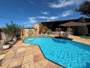 A swimming pool with a stone patio, outdoor furniture, and a brick building in the background. - 10 minutes from Beach Park - House with sea view 50m from the beach (Aquiraz)