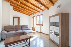 A living room with a wooden ceiling, a sofa, a table, and a cabinet. - Mirafiume - Lugano Lake (San Mamete)