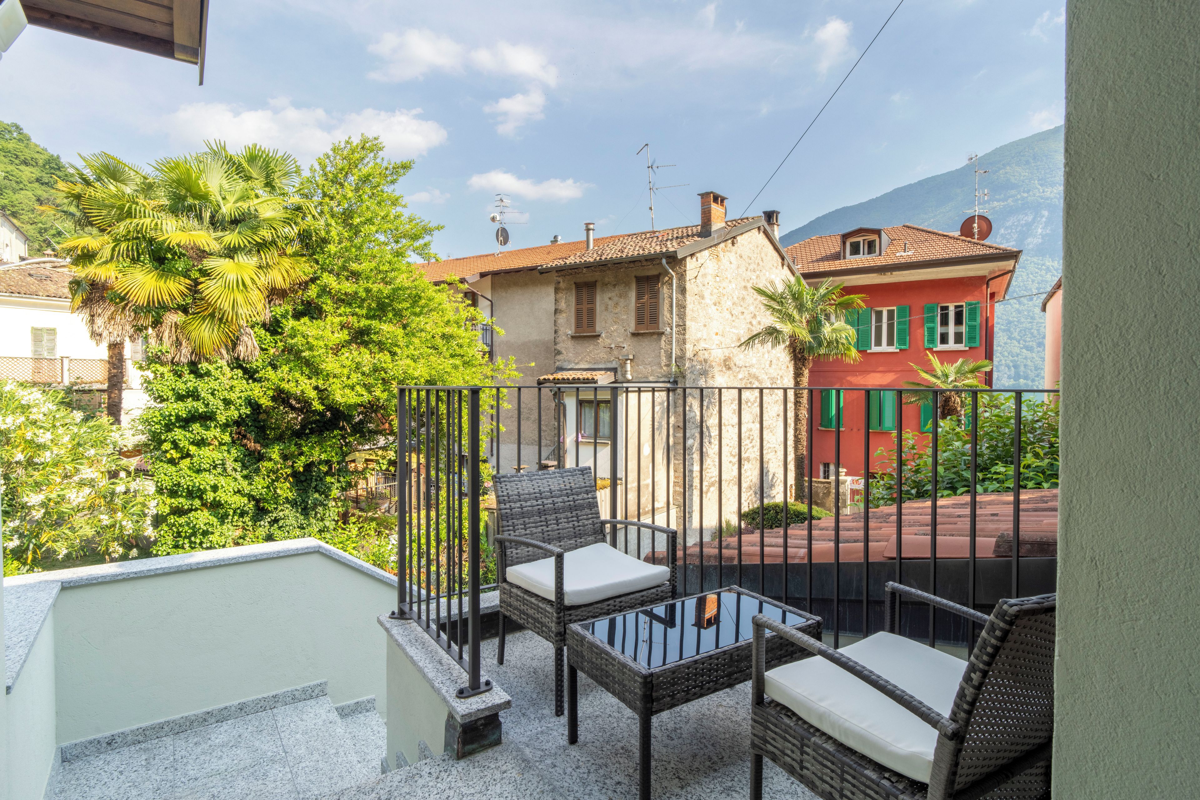 Un balcon doté de meubles en osier et offrant une vue sur une montagne.