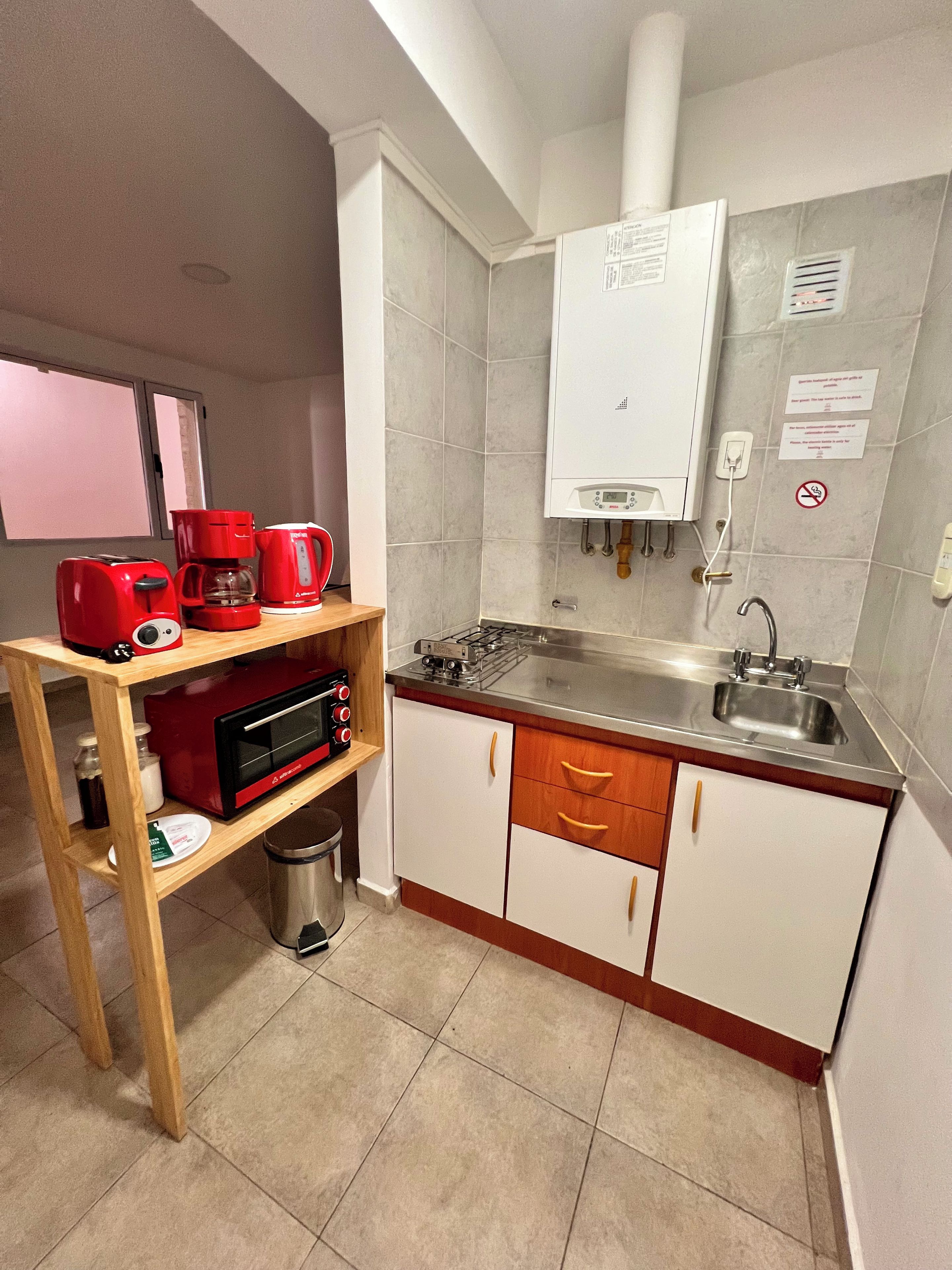 A compact kitchen with a microwave, coffee maker, and a gas stove.