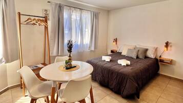A bedroom with a bed, bedside table, lamp, and a window with curtains.
