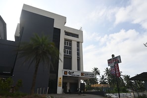 A hotel with a modern design, featuring a prominent entrance and signage for the hotel and a nearby restaurant. - Reunion D Square Hotels & Resorts (Kundapur)