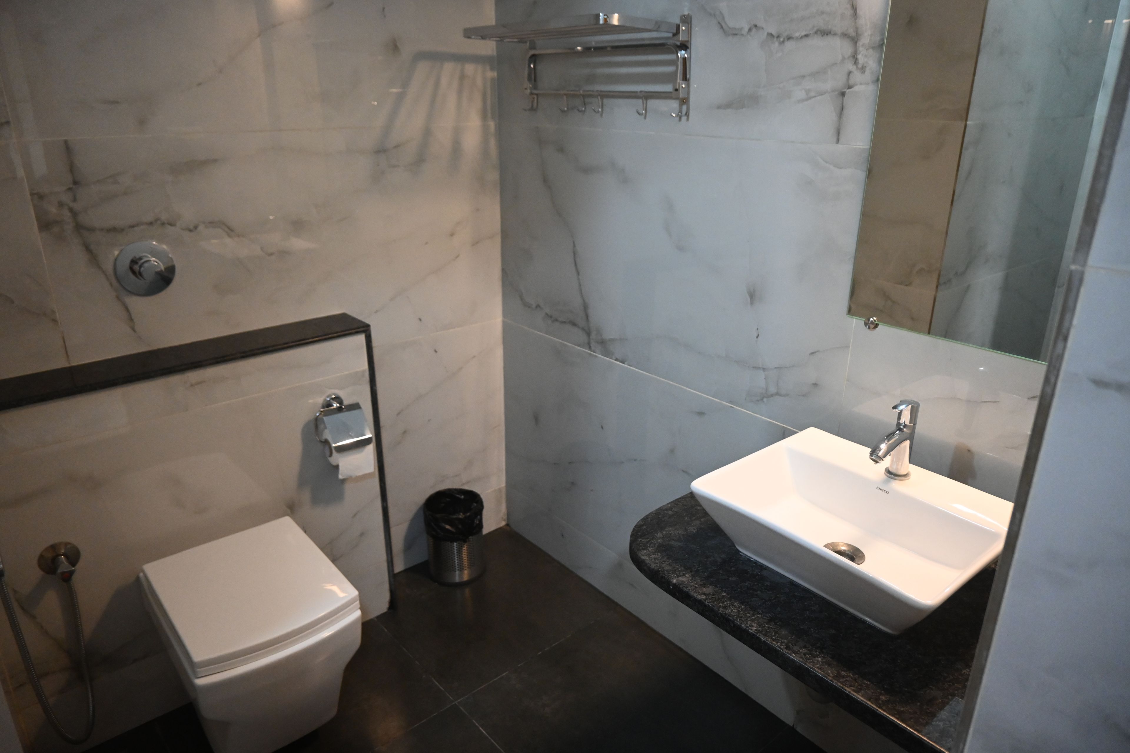 A modern bathroom with a toilet, sink, and mirror.