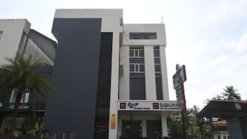 A modern hotel with a reception area, a signboard for 'SQUA' hotels & resorts, and a gated entrance.