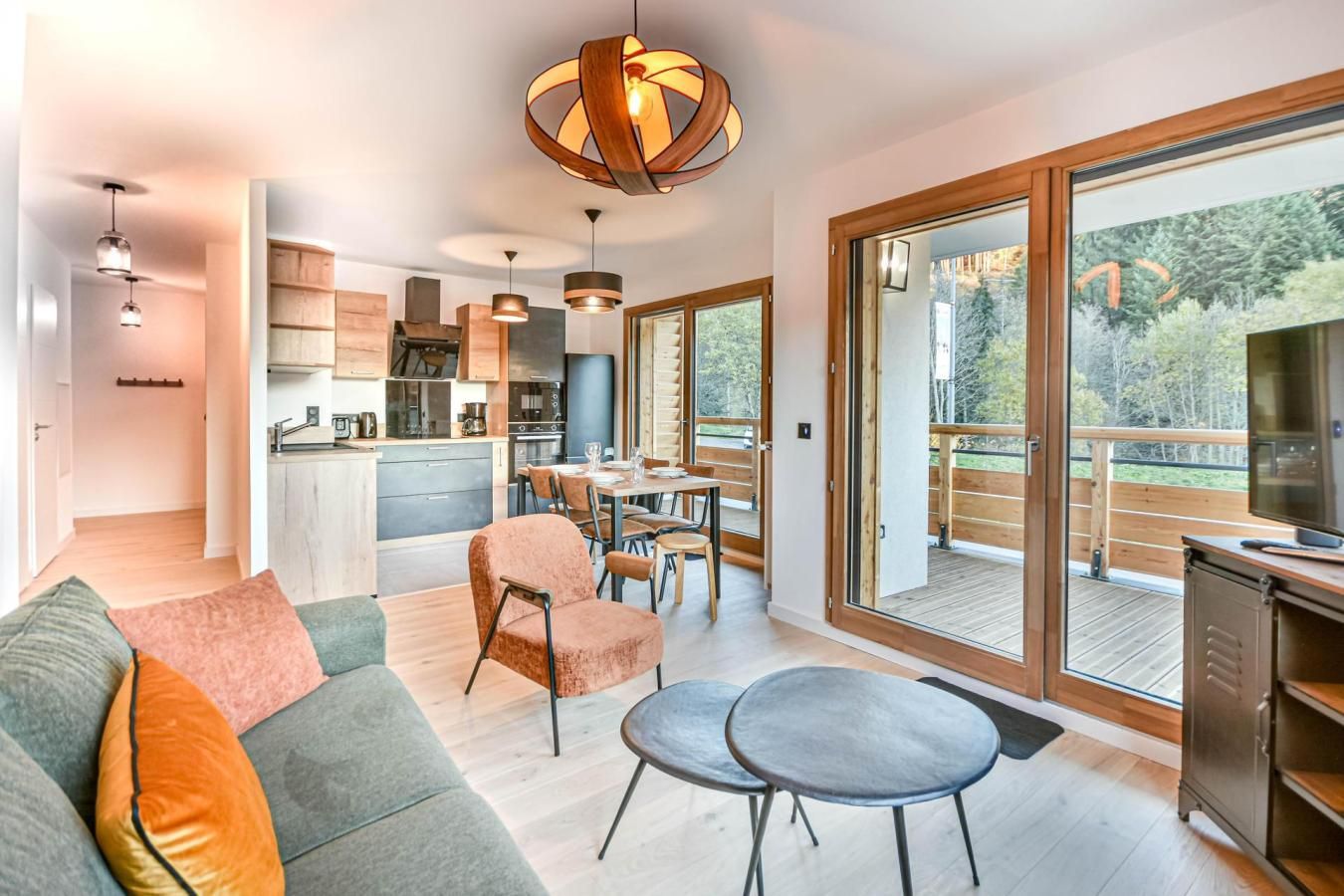 A modern living space with a sofa, chairs, a dining table, and a kitchen area.