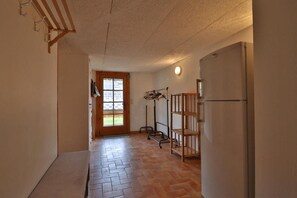 A hallway with a tiled floor, a wooden door, a coat rack, and a refrigerator. - Chalet, wifi, Ground floor, terrace, balcony, fireplace or stove, parking, 94m², Les Gets (Les Gets)