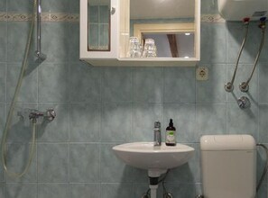 Un baño con lavamanos, espejo y ducha.
