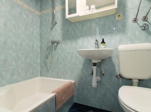Un baño con bañera, lavamanos e inodoro.