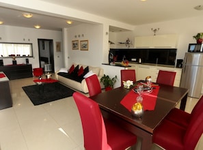 A modern living room with a dining area, a kitchen, and a separate bedroom. - Two Bedroom Apartment Sea View with Balcony (Okrug Gornji)