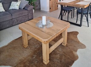 A living room with a wooden coffee table, a sofa, and a dining area. - Two Bedroom Holiday Home with Outdoor Swimming Pool (Murter)