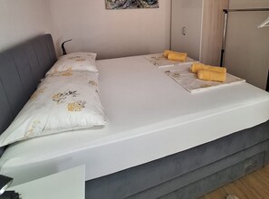 A bedroom with a bed, pillows, a bedside table, and a wall-mounted artwork. - Two Bedroom Holiday Home with Outdoor Swimming Pool (Murter)
