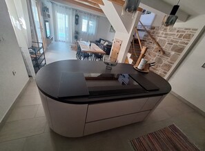 A kitchen with a central island, a dining area with a table and chairs, and a staircase leading to an upper level. - Two Bedroom Holiday Home with Outdoor Swimming Pool (Murter)