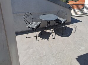A small outdoor seating area with a round table and two chairs, featuring a patterned cushion on one chair. - Two Bedroom Holiday Home with Outdoor Swimming Pool (Murter)