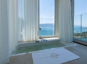 A room with a large window overlooking a body of water and a mountainous landscape. - Six Bedroom Sea View Villa with Two Swimming Pools (Blace)