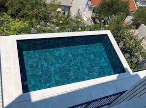 A rectangular swimming pool with clear blue water, surrounded by a white pool deck and a metal railing. - Six Bedroom Villa with Sea View & Two Pools (Blace)