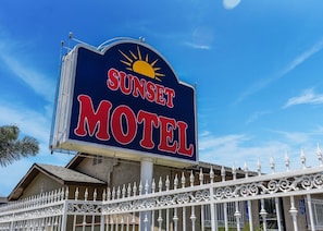 A motel sign with a sun graphic and the name 'Sunset Motel' in bold letters. - Sunset Motel (Pomona)