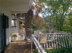 A covered outdoor area with a metal railing, a bench, and a potted plant. - Two Bedroom with Balcony (A3) (Marina)