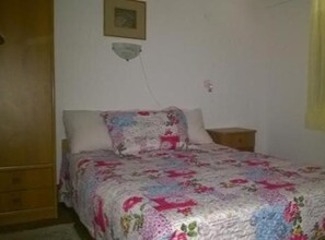 A bedroom with a bed, a nightstand, a wall-mounted light, and a door. - Three Bedroom Apartment with Terrace (A2) (Marina)