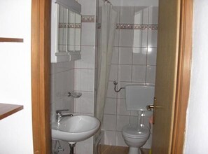 Een badkamer met een wastafel, toilet en douchegordijn.
