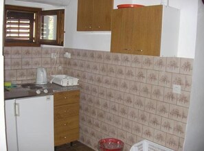 A small kitchen with a refrigerator, stove, and wooden cabinets. - One Bedroom Classic apartment with Terrace and Sea View (A5) (Marina)