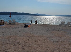 Una playa con tumbonas y una vista despejada del mar.