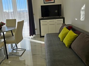 A modern living room with a sofa, chairs, a TV, and a cabinet. - One Bedroom Apartment with Balcony (Trogir)