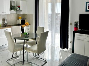 A modern kitchen with white cabinets, a microwave, and a coffee machine. - One Bedroom Apartment with Garden View and Pool (Trogir)