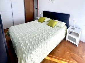 A bedroom with a bed, nightstand, and wardrobe. - One Bedroom Apartment with Garden View and Pool (Trogir)