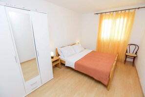 A bedroom with a bed, nightstand, wardrobe, and a chair. - Apartment 'Panorama' with Sea View, Wi-Fi and Air Conditioning (Pakoštane)