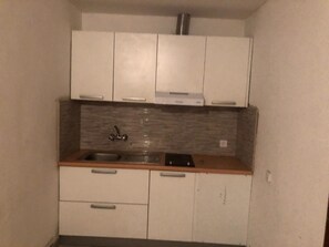 A compact kitchen with white cabinets, a stainless steel sink, and a tiled backsplash. - Apartment 'Panorama' with Sea View, Wi-Fi and Air Conditioning (Pakoštane)