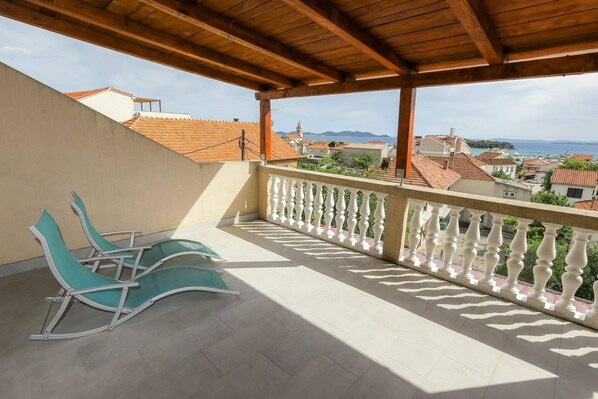 A balcony with a wooden ceiling, a white balustrade, and two green chairs. - Apartment 'Panorama' with Sea View, Wi-Fi and Air Conditioning (Pakoštane)