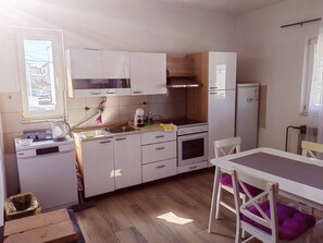 A compact kitchen with a dishwasher, oven, and a small refrigerator. - Apartment 'Family Apartments' with Sea View, Wi-Fi and Air Conditioning (Pakoštane)
