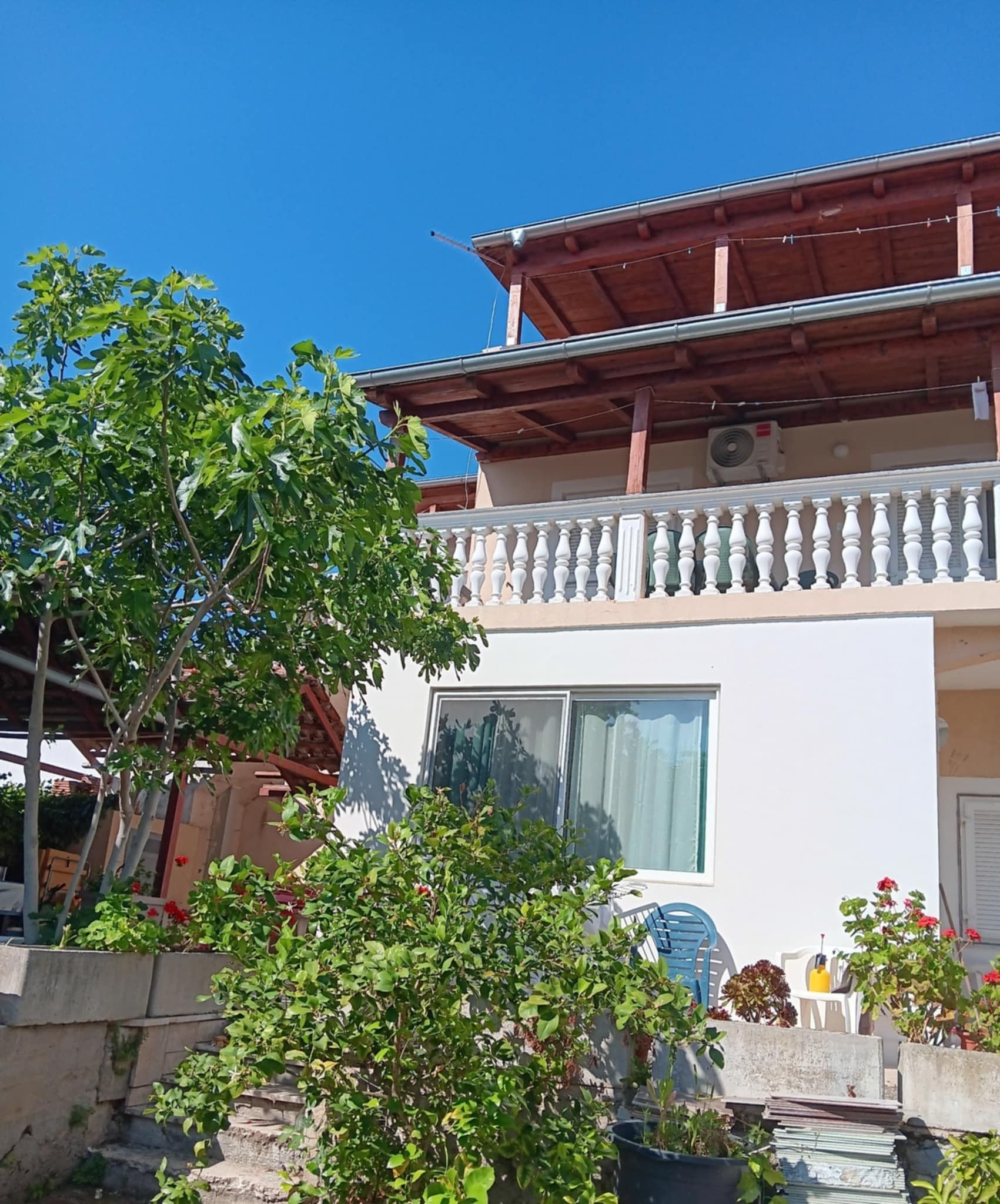 A two-story building with a balcony, a window, and a door.