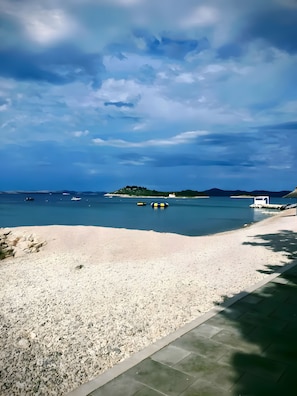 A pebble beach with a clear view of the sea and distant land. - Apartment 'Mediterranean' with Sea View, Wi-Fi and Air Conditioning (Pakoštane)