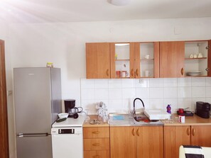 Cuina amb nevera, cafetera, rentapelats i armaris de fusta.