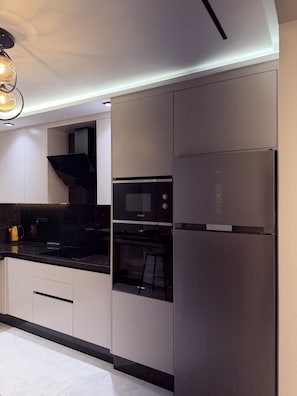 Eine moderne Küche mit integrierten Geräten, darunter ein Backofen von Bosch und ein Kühlschrank von Whirlpool.