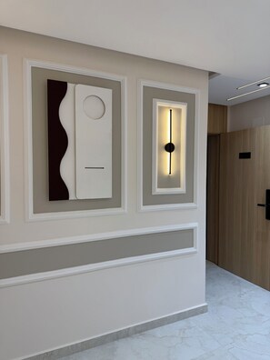 Ein Flur mit modernem Wanddesign, eingelassener Beleuchtung und einer Holztür.