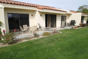 A house with a patio, outdoor furniture, and a lawn. - Great location on 11th Fairway! (Palm Desert)